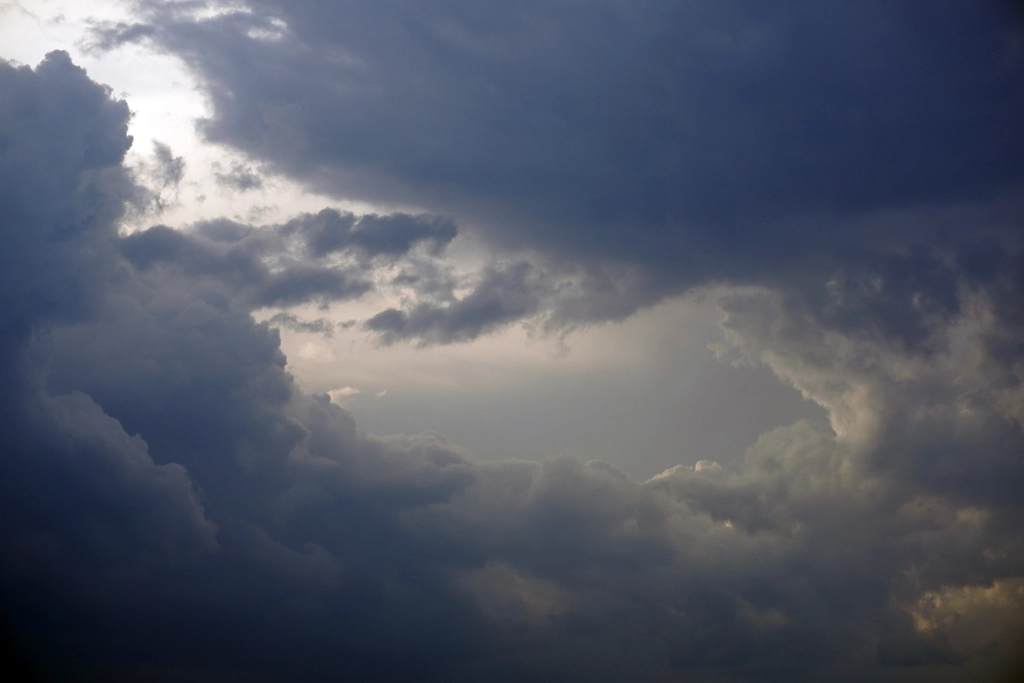 Dark storm clouds over a city skyline