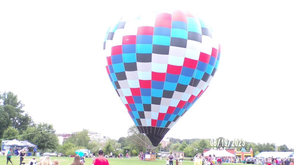 Hot air balloon over a festival field